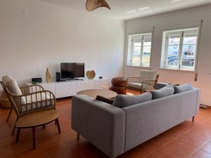 sala de estar con sofá, sillas y TV en SW Beach House Almograve - Unique Stays, en Almograve