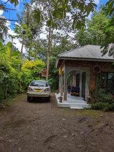 a car parked in front of a small house at Arusha Holiday Safari in Arusha