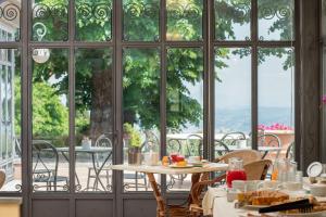 una mesa y sillas en una habitación con ventanas en Relais Villa Bianca, en Gambassi Terme