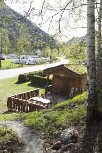a wooden cabin with a bench and a table at Valldal Camping in Valldal