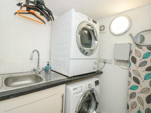 a kitchen with a washing machine and a sink at Spinners House in Dartmouth