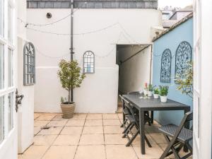 Un patio al aire libre con mesa y sillas. en Spinners House, en Dartmouth