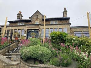 an old house with a garden in front of it at The Cross Scythes in Sheffield