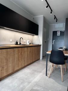 a kitchen with a counter and a table and a chair at Property Apart – Legnicka Business Center in Wrocław
