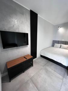 a bedroom with a bed and a flat screen tv at Property Apart – Legnicka Business Center in Wrocław