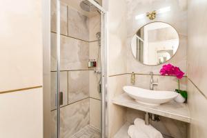 La salle de bains est pourvue d'un lavabo et d'un miroir. dans l'établissement Luxury 2 Bedroom - Eiffel-Tower & Orsay Museum, à Paris