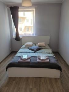 a bedroom with a bed with towels on it at Apartament Słowińców 35 in Wejherowo