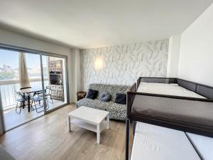 een woonkamer met een bed en een bank bij Marina 26 - Estudio totalmente reformado in Roses