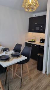 a kitchen with a table and two chairs and a kitchen with a sink at La Suite de Lily in Talence