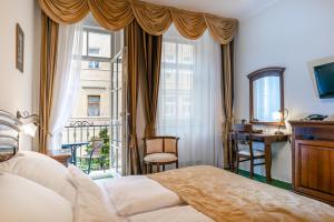 1 dormitorio con cama, escritorio y ventana en Spa Hotel Schlosspark, en Karlovy Vary