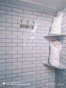 ein Badezimmer mit blau gefliesten Wänden und Regalen mit Handtüchern in der Unterkunft Chalets ITO Atlas Timnay in Midelt