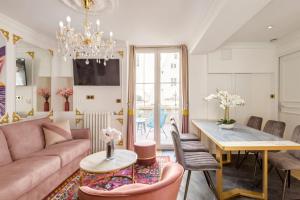 a living room with a pink couch and a table at Luxury 2 Bedroom Eiffel-Tower with Terrace in Paris