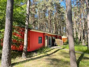SilzにあるHoliday Home Silz am Fleesensee-2 by Interhomeの木々の木々が茂る赤い小屋