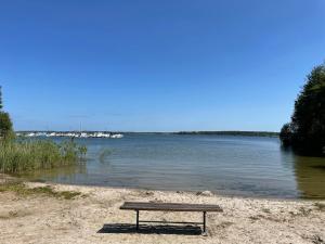 a bench sitting on a beach near a body of water at Holiday Home Silz am Fleesensee-1 by Interhome in Silz