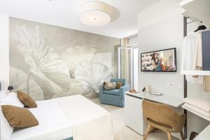 a bedroom with a bed and a desk in a room at Hotel Jasminum in Bibione