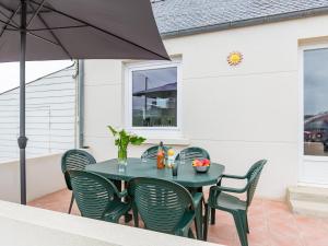 una mesa y sillas en un patio con sombrilla en Holiday Home Brise Marine by Interhome, en Cléder