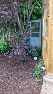 a garden with a blue door and a bench at Glamping in the 2nd Field in Aughrim