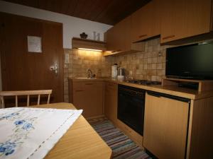 施文道Apartment Schusterhäusl-1 by Interhome的一间带桌子和电视的小厨房