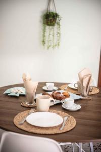 a wooden table with plates and cups on it at Angolo Di Dante in Nardò