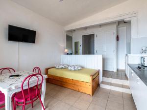 um pequeno quarto com uma cama, uma mesa e cadeiras em Apartment Punta Paliagi - TUC160 by Interhome em Calcatoggio