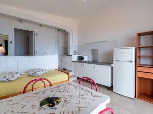 Il comprend une cuisine équipée de 2 lits, d'une table et d'un réfrigérateur. dans l'établissement Apartment Punta Paliagi - TUC160 by Interhome, à Calcatoggio