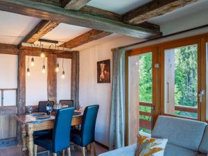 een eetkamer met een tafel en blauwe stoelen bij Apartment Quille du Diable 44 by Interhome in Nendaz