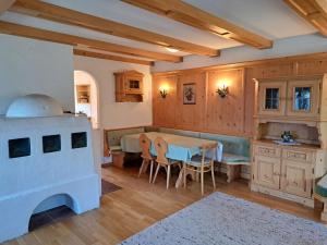 een keuken met houten kasten en een tafel en stoelen bij Holiday Home Ragusa - ZAZ390 by Interhome in Hainzenberg
