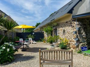 a wooden bench sitting in front of a stone building at Holiday Home Belon by Interhome in Trégunc