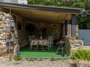 a patio with a table and chairs and a grill at Holiday Home Belon by Interhome in Trégunc