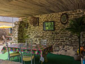 a table and chairs in front of a stone wall at Holiday Home Belon by Interhome in Trégunc +25 photos