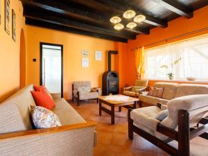 バラトンマーリアフュルドゥーにあるHoliday Home Pergola by Interhomeのオレンジ色の壁のリビングルーム(ソファ付)