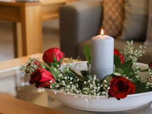 een kaars en bloemen in een kom op een tafel bij Apartment Cor des Alpes 16 by Interhome in Nendaz