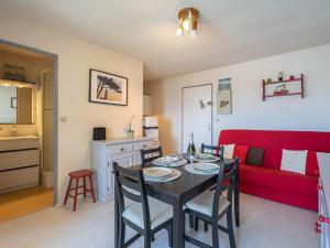 een woonkamer met een tafel en een rode bank bij Apartment Les Balcons de l'Atlantique-11 by Interhome in Pontaillac