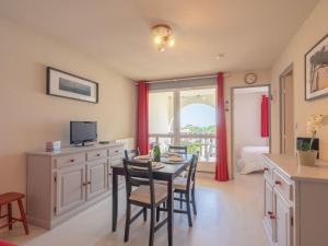 a kitchen and dining room with a table and chairs at Apartment Les Balcons de l'Atlantique-11 by Interhome in Pontaillac