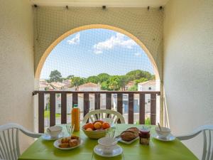 uma mesa verde com comida em cima de uma varanda em Apartment Les Balcons de l'Atlantique-11 by Interhome em Pontaillac