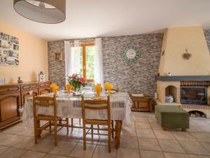 a dining room with a table and chairs and a fireplace at Holiday Home Chastagnol by Interhome in Le Chastang