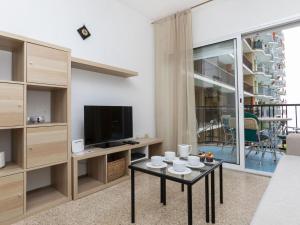 a living room with a tv and a table at Apartment Olivier by Interhome in Blanes