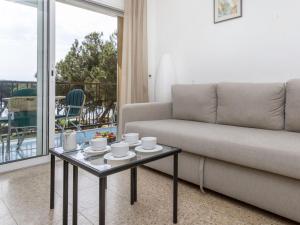 a living room with a couch and a coffee table at Apartment Olivier by Interhome in Blanes +9 photos