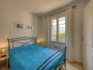 a bedroom with a blue bed and a window at Holiday Home Les Grandes Bleues 2-1 by Interhome in Narbonne-Plage