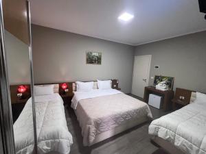 um quarto de hotel com duas camas e duas lâmpadas em Bobi Hotel em Shkodër