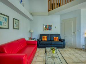 salon z czerwoną kanapą i stołem w obiekcie Holiday Home Les Grandes Bleues 2-1 by Interhome w mieście Narbonne-Plage