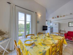 a dining room with a table with a yellow table cloth at Holiday Home Les Grandes Bleues 2-1 by Interhome in Narbonne-Plage