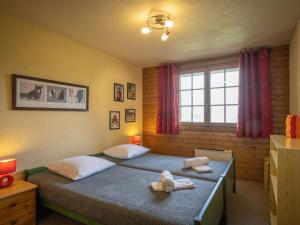 una camera con due letti, asciugamani e finestra di Chalet Les Falaises by Interhome a Ovronnaz