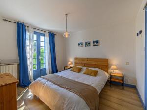 1 dormitorio con 1 cama grande y cortinas azules en Villa Mané by Interhome, en La Trinité-sur-Mer