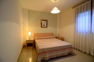 a small bedroom with a bed and a window at Apartamentos Mestral in L'Escala
