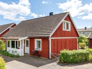 un granero rojo con una puerta blanca y un porche en Holiday Home Mölltorp - VGT119 by Interhome, en Mölltorp