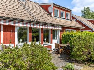 una casa roja con mesa y sillas en Holiday Home Mölltorp - VGT119 by Interhome en Mölltorp