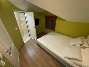 Dormitorio pequeño con cama con paredes verdes en Zabljak Crnojevica ( National Park Skadar Lake), en Žabljak