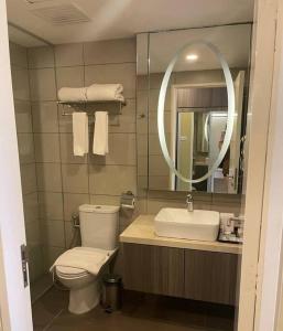 ein Badezimmer mit einem WC, einem Waschbecken und einem Spiegel in der Unterkunft Harmony Sweet Home @ Genting Top Grand Ion Delemen in Genting Highlands