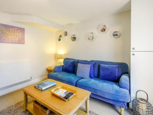 a living room with a blue couch and a table at Apartment Horizons by Interhome in Ilfracombe